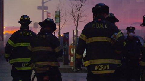 NEW YORK - MARCH 26, 2015: heroic FDNY firefighters walking toward fire, silhouetted, smoke, on the job in 4k, Manhattan NYC. FDNY responded to disaster; building collapse and fires in East Village.