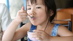 Asian child eating an ice creme in relax time .