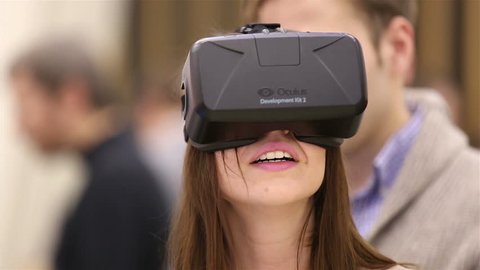 MOSCOW, RUSSIA - MARCH 29, 2015: Virtual reality game. Girl uses head mounted display Oculus Rift. Exhibition of modern technologies TechTrends Expo.