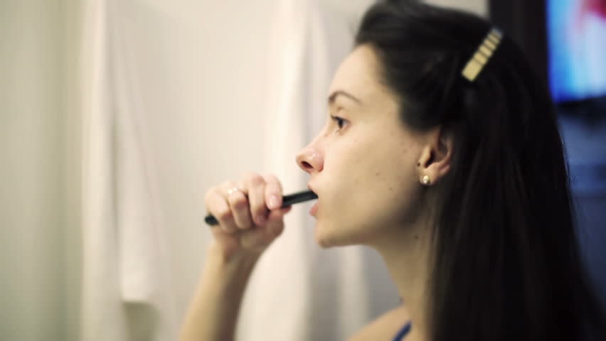 Young woman brushing teeth in bathroom of the hotel for checkout | Shutterstock HD Video #9462011