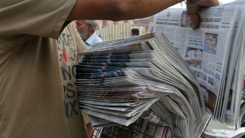 AMRITSAR, INDIA - 3 OCTOBER 2014: Men are organizing newspapers in the early morning, to transport them with their bicycles, on the streets of Amritsar.