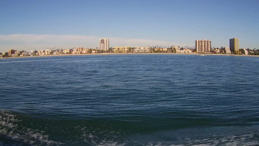 LONG BEACH, CA/USA - March 11, 2015- The Long Beach California shoreline from a fast moving boat in the harbor. Vehicle shot showing the buildings of the city along the beach front in 4K format.