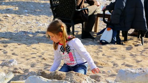 MONTENEGRO - BUDVA 2015 - Little girl is playing in the sand on the beach