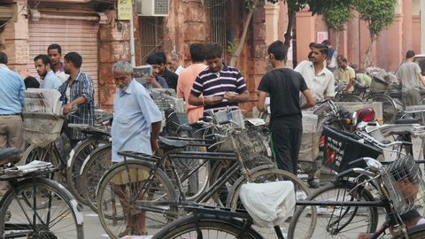 AMRITSAR, INDIA - 3 OCTOBER 2014: Men sort newspapers in the early morning, in order to distribute them on their bicycles, in Amritsar.