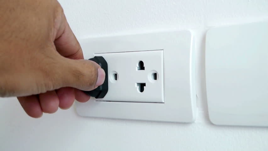 Left man hand plugging and unplugging electronic into electric wall socket. | Shutterstock HD Video #9473906