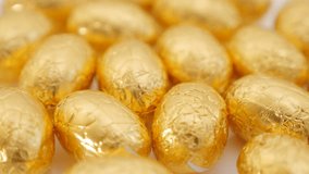 Easter chocolate golden eggs on white surface 4K 2160p UltraHD footage - Slow tilting  over golden Easter chocolate eggs 4K 3840X2160 UHD video