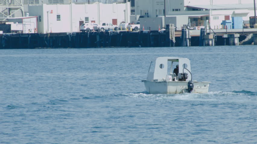 A SMALL, WELL SEASONED & WEATHERED BOAT MAKES A TURN IN SAN PEDRO HARBOR IN CALIFORNIA.  BOAT CONTAINS ONE UNRECOGNIZABLE MALE OCCUPANT.