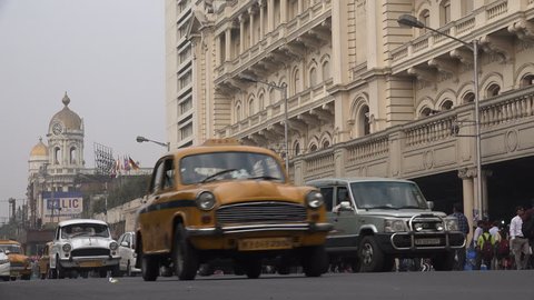 KOLKATA, INDIA - 13 DECEMBER 2014: Traffic drives past a colonial style building, currently used as a shopping mall, in Kolkata.