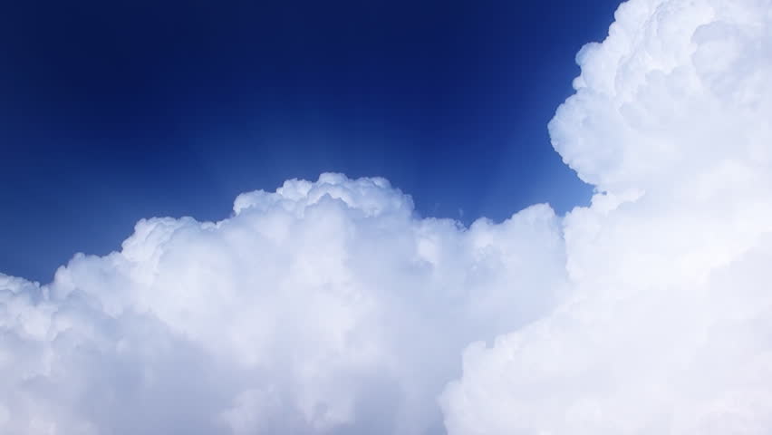 Time lapse clip of white fluffy clouds over blue sky 