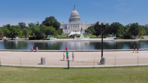 WASHINGTON - AUG 26, 2014: People walk near Capitol Reflecting Pool, Ulysses S. Grant Memorial and United States Capitol at summer day. Aerial view. Ulysses S. Grant was  the 18th President of US.
