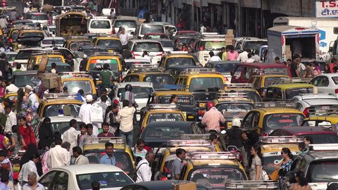 MUMBAI, INDIA - 8 NOVEMBER 2014: Major traffic jam in front of a busy bazaar in Mumbai. The streets are filled with cars, pedestrians, workers, and others.