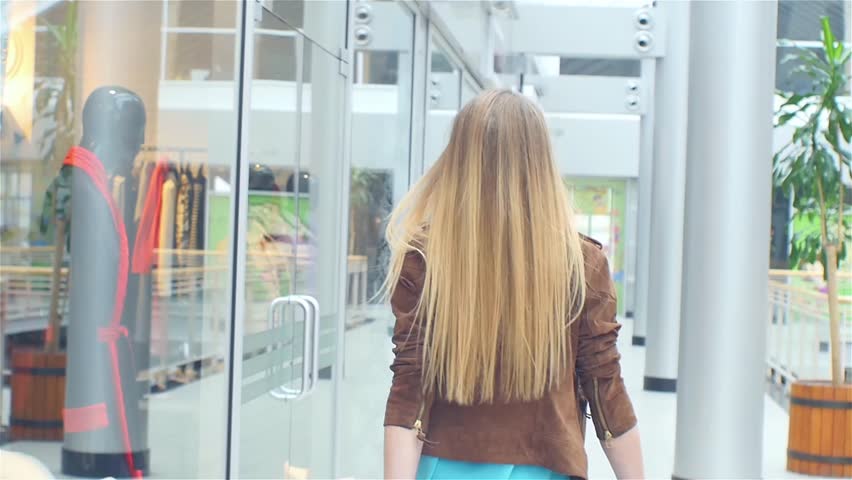 Beautiful blonde goes to the store, bags thrown behind his back, Slow motion