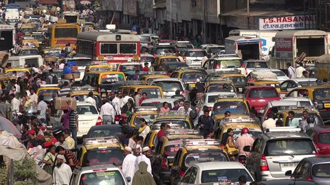MUMBAI, INDIA - 8 NOVEMBER 2014: Traffic makes its way through a busy and chaotic street in front of a popular bazaar, during rush hour in Mumbai.