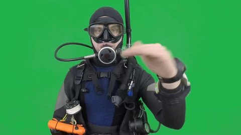 Dive instructor shows sing:THE SAME DEPTH, ONE LEVEL also a available on the green screen all of diving sings from course  with full dive gear (open water diver)