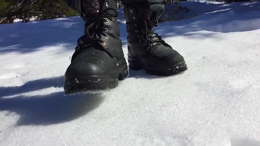 Safety boots walking in the snow slow motion video 