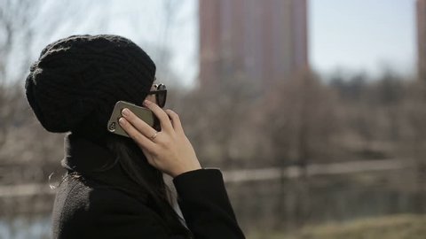 Young girl in sunglasses speaks by phone. Slow motion