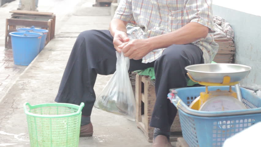 close-up seller putting fresh catfish in the plastic bag, thailand
