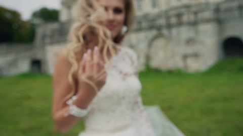 Dynamic video of a beautiful blonde in white dress with long hair. Summer beautiful shots from professional models