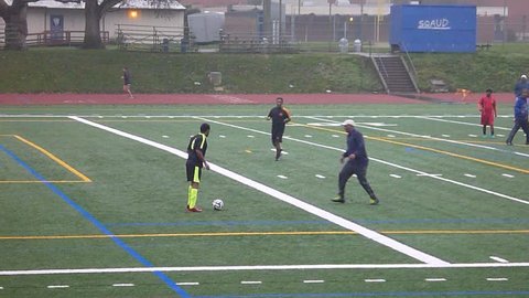 PORTLAND, OREGON - CIRCA 2015: Players join together at community soccer field to play pick-up game in the rain over the weekend.