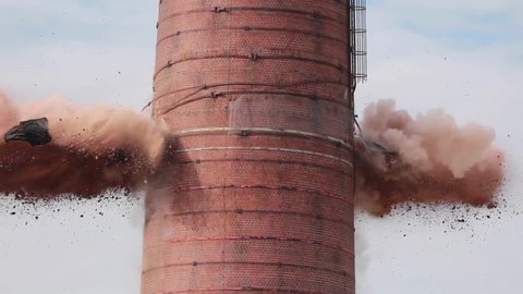 Explosion as smoke stack implodes and crumbles