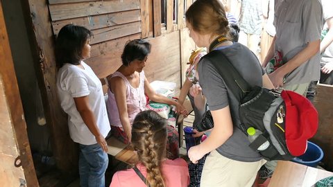 BANGKOK, THAILAND, MARCH 2015: A group of high school students on an overseas missions trip pray for people in the slums of Bangkok, Thailand.