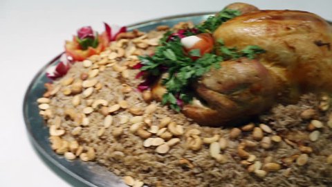 Serving rice and chicken meal, Kabsa.
Kabsa is a family of mixed rice dishes that are served mostly in the middle east.These dishes are mainly made from a mixture of spices, rice, meat and vegetables