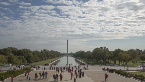 WASHINGTON D.C., USA - OCT 14, 2012: 4K time lapse crowd of people walking around at Washington Monument view from Lincoln Memorial with dark cloudes in the sky