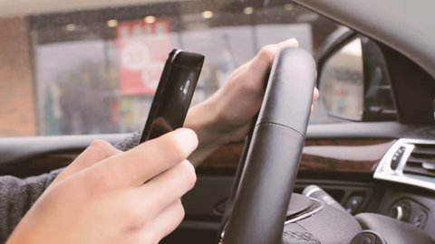Distracted driver using phone to text while driving 