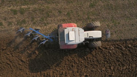 Aerial, vertical - Tractor with four furrow plough plowing a field