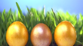 Easter golden eggs on fresh green grass background. Easter Spring Holidays nature background. Slow motion 240 fps. High speed camera shot. Full HD 1080p. 