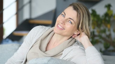 Mature woman relaxing at home sitting on couch