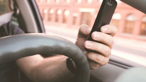 Distracted driver texting while driving through city traffic 