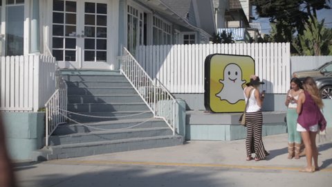 Venice Beach, California, USA – August 19, 2013: Three young women texting on their phones in from the SnapChat headquarters. Documentary Editorial.