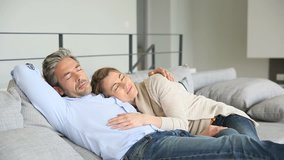 Mature couple relaxing together in couch 