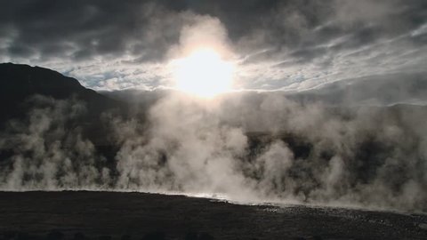 Spring with natural thermal water produce hot steam at sunrise at the famous El Tatio geyser valley at 4320 meters above sea level, Chile.
