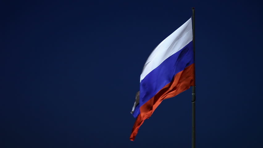 Russian flag waving on flagstaff in blue sky background  