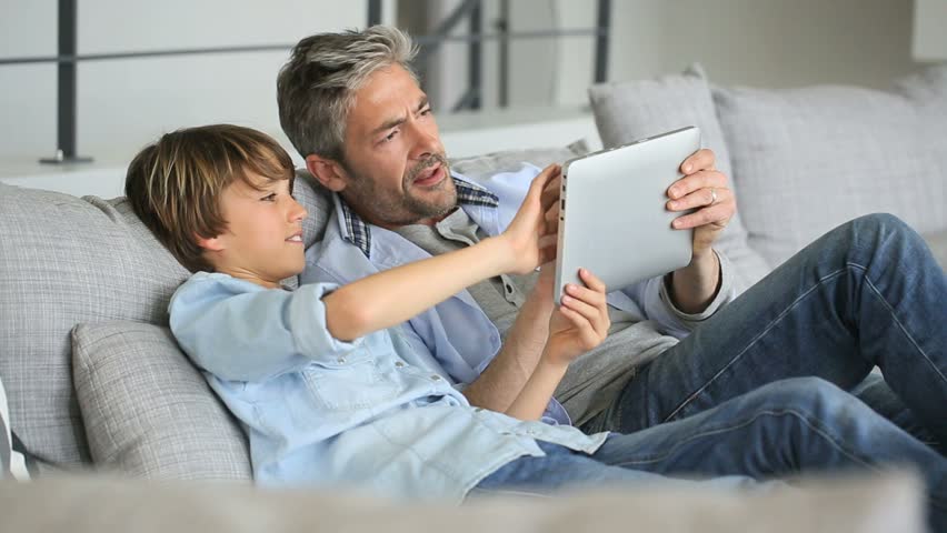 Daddy and son websurfing on digital tablet at home Royalty-Free Stock Footage #9607166
