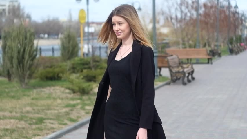 Young blond haired women walking or dancing in emotional state outdoors.