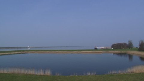 Inland harbour Houtribhaven + pan towards Houtribdijk, part of the Zuiderzee Works. The dam connects the cities of Lelystad and Enkhuizen. LELYSTAD, THE NETHERLANDS - APRIL 2015