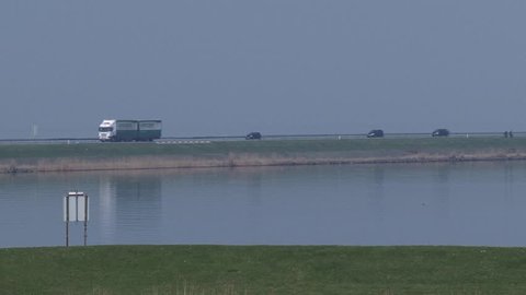 LELYSTAD, THE NETHERLANDS - APRIL 2015: Traffic across Houtribdijk, part of the Zuiderzee Works. The dam connects the cities of Lelystad and Enkhuizen and separates the lake IJsselmeer and Markermeer