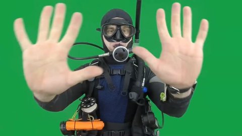 Dive instructor shows sing: COUNTING also a available on the green screen all of diving sings from course with full dive gear (open water diver) TEN