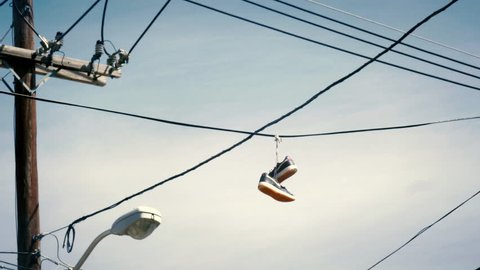 Sneakers hanging from telephone wire in a bad neighborhood is a symbol for a drug dealer 