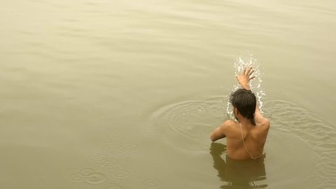 india, varanasi, man bathing in ganges river, march 2015