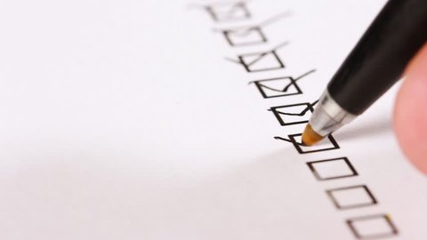 A person checking off a to do list. Check all the boxes of a checklist