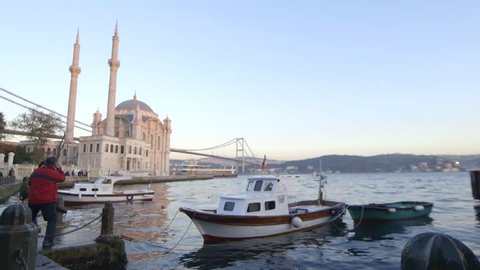 Istanbul, Turkey, October, 2014. A Time-lapse of the sun coming down from day to night-Sunset for the famous Bosphorus bridge with boats floating in the sea - Istanbul, Turkey.