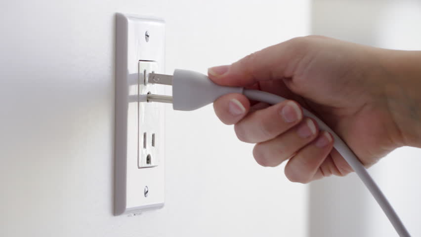 Close up of a hand plugging in a power cord and then unplugging it in a typical electrical outlet cover in the USA.  Originally recorded in 4K | Shutterstock HD Video #9644456