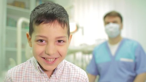 Happy doctor and happy patient. Portrait of happy young boy and a dentist smiling at camera (Packshot)