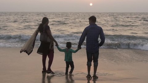 happy indian family together hand in hand on alappuzha beach, march 2015