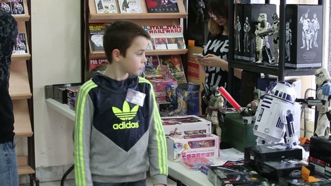 MOSCOW, RUSSIA - MARCH 28, 2015: Star Wars Cosplay show. The children consider toys and the Star Wars logo in a special shop. Festival Star Fans.