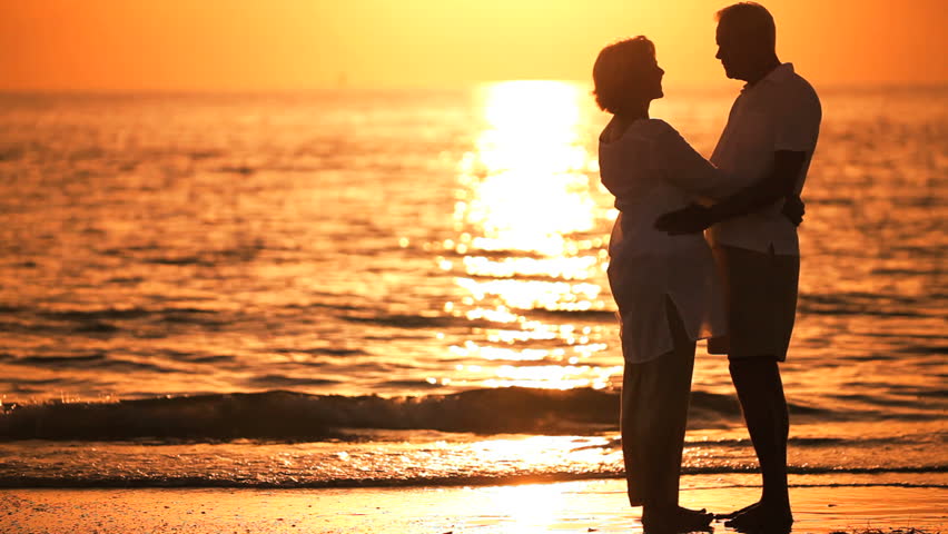Healthy & affectionate senior couple enjoying a romantic sunset evening together on the beach | Shutterstock HD Video #966256